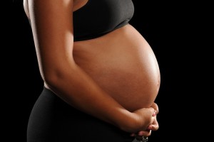 Young African American Woman Pregnant isolated on a black backgr